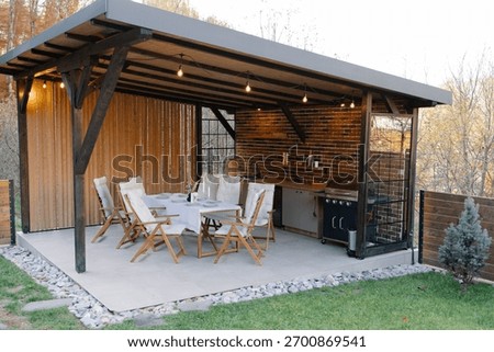 Outdoor kitchen and dining setup with brick wall and wooden elements, perfect for gathering