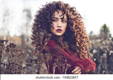 Outdoor Lifestyle Fashion Photo Of Young Natural Beautiful Lady In Autumn Landscape With Dry Flowers. Knitted Sweater, Wine Lipstick. Warm Autumn. Fall Vibes