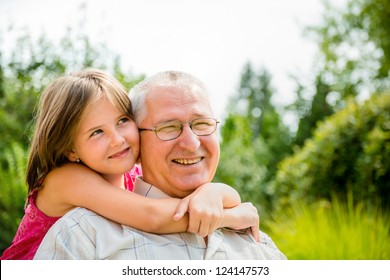 Outdoor lifestyle portrait of grandchild embracing grandfather - Powered by Shutterstock