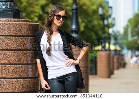 Outdoor lifestyle portrait of pretty stylish and fashionable young model in the city