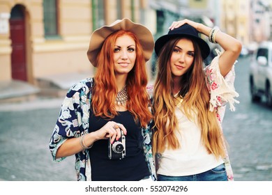 Outdoor lifestyle portrait of two best friends, having fun together, joy and happiness, wearing trendy wool hat, stylish vintage bohemian outfits. Fall fashion. Photo toned style instagram filters.