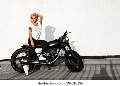 Outdoor Lifestyle Portrait Of Young Biker Woman Sitting On A Vintage Custom Motorcycle