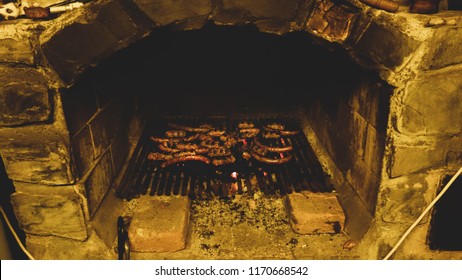 An Outdoor Masonry Oven With Sausages And Cevapcici Inside
