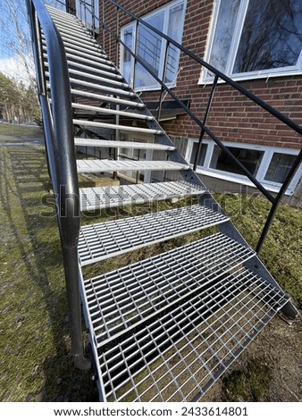 Outdoor metal staircase fireescape at a brick building.