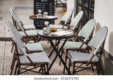 Outdoor café with neatly arranged chairs and tables, creating a cozy, inviting atmosphere for diners - Powered by Shutterstock