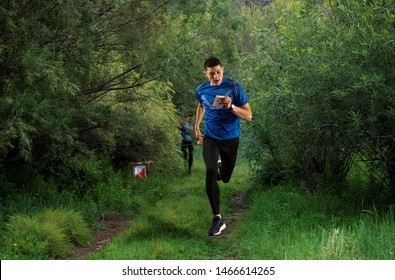 Outdoor orienteering check point activity.  Man runs with map and compass. Professional orienteering sport   - Shutterstock ID 1466614265