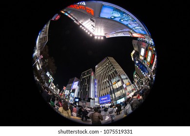 Outdoor Panoramic Scenic View At Shinjuku Downtown At Night In Tokyo, Japan In March 15 2018. Pedestrians Walking Around Numerous Skyscrapers. Fish Eye Lens Uses For The Special Plate Effect.