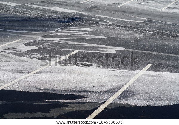 outdoor parking lot with snow removed and sprayed salt  
        