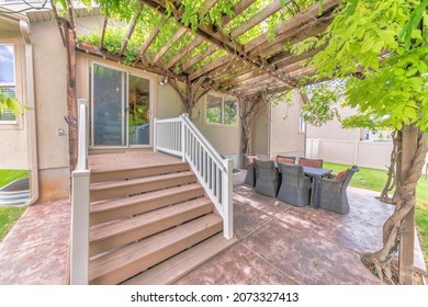 Outdoor Patio With Wooden Pergola Roof With Vines And String Lights