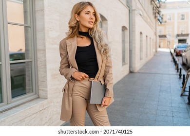 Außenfoto einer schönen blonden Studentin mit schweren Haaren   in Gelegenheitsartikeln, die mit Notebooks im Freien stehen. Geschäfts- und Studienkonzept.