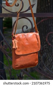 Outdoor Photo Of A Orange Leather Messenger Bag.