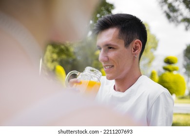 Outdoor Photo Of Young And Modern Man Drinking Natural Orange Juice In Nature, Sunlight Photography