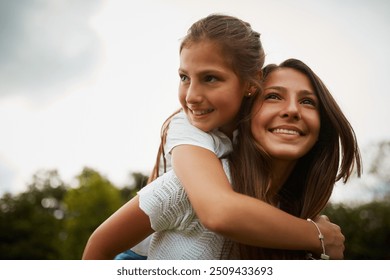 Outdoor, piggyback and sister with smile, child and bonding in nature, thinking and happy in forest. Love, girls and fun in woods, carrying and teenager with care for kid, siblings and contemplating - Powered by Shutterstock