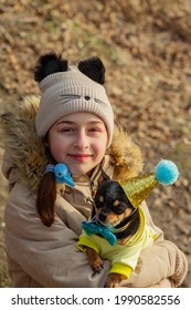 Outdoor Portrait Of 10- 11 Year Old Girl Wearing Warm Beige Jacket With A Chihuahua Dog. Birthday