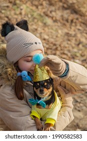 Outdoor Portrait Of 10- 11 Year Old Girl Wearing Warm Beige Jacket With A Chihuahua Dog. Birthday