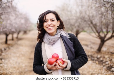 Outdoor Portrait Of 40 Years Old Woman Holding Red Apples