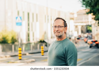 Outdoor Portrait Of 50 - 55 Year Old Man Wearing Green Pullover And Eyeglasses