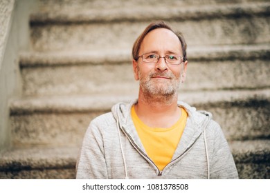 Outdoor Portrait Of 50 Year Old Man Wearing Grey Hoody And Eyeglasses