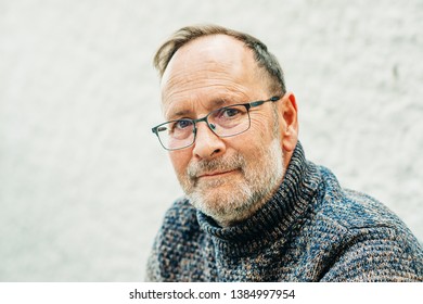 Outdoor Portrait Of 50 Year Old Man Wearing Brown Pullover And Eyeglasses