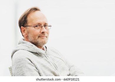 Outdoor Portrait Of 50 Year Old Man Wearing Grey Hoody And Eyeglasses