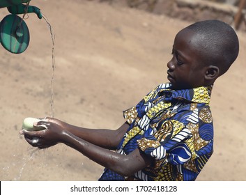 Outdoor Portrait of African Black Boy Washing Hands Outdoors to Fight Coronavirus Virus or Bacteria