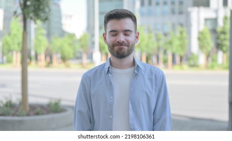 Outdoor Portrait Of Agree Young Man Shaking Head In Approval