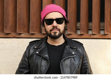 Outdoor Portrait Of Beard Hipster Man Posing In Leather Jacket And Beanie Hat.