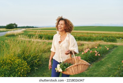 Outdoor portrait of beautiful 50 year old woman enjoying nice day in flower park or garden, happy and healthy lifestyle - Powered by Shutterstock