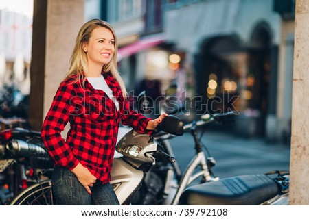 Outdoor portrait of beautiful blond woman wearing red plaid shirt