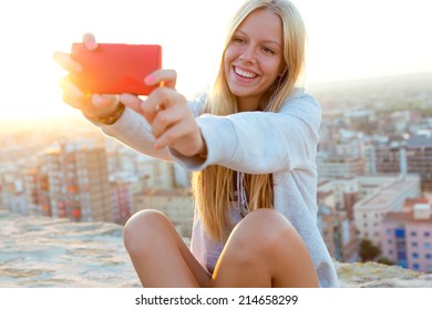 Outdoor Portrait Of Beautiful Blonde Girl Taking A Selfie On The Roof.