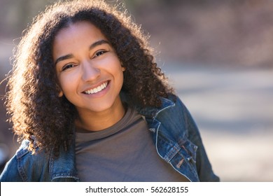 Outdoor portrait of beautiful happy mixed race biracial African American girl teenager female young woman smiling laughing with perfect teeth