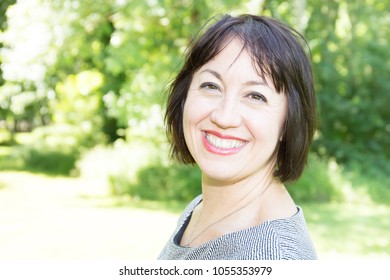 Outdoor portrait of a beautiful middle aged brunette woman in forties years