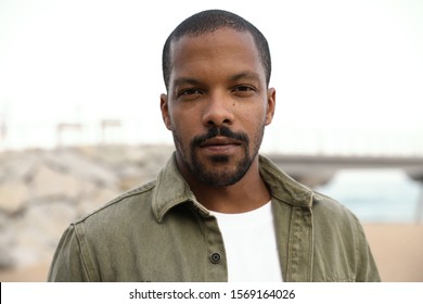 Outdoor Portrait Of Black Man Looking Straight At The Camera And Wearing Casual Clothing.