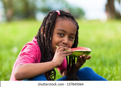 Outdoor Portrait Of A Cute Young Black Little  Girl Eating Watermelon - African People