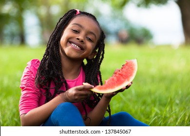 Outdoor Portrait Of A Cute Young Black Little  Girl Eating Watermelon - African People