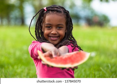 Outdoor Portrait Of A Cute Young Black Little  Girl Eating Watermelon - African People