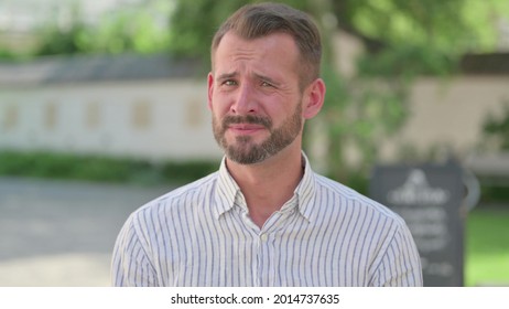 Outdoor Portrait of Disappointed Mature Adult Man Reacting Loss 