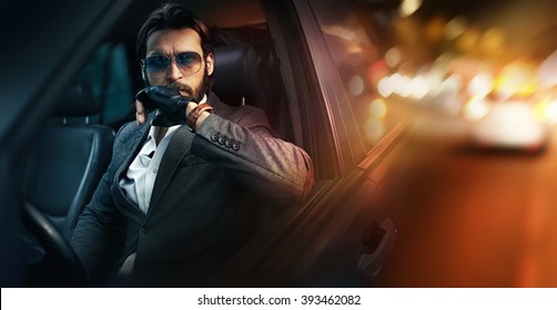 Outdoor portrait of elegant man driving a car