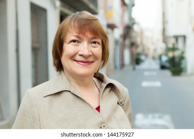 Outdoor Portrait Of European Mature Woman In Old City Street