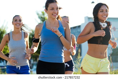 Outdoor Portrait Of Group Of Women Running In The Park. 