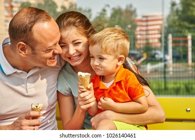 Outdoor Portrait Of A Happy Family. Mom, Dad And Child Eating Ice Cream