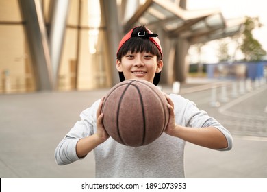 outdoor portrait of a happy fifteen-year-old asian teenage basketball player - Powered by Shutterstock