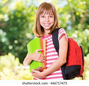 Outdoor Portrait Of Happy Girl 10-11 Year Old With Books. Back To School Concept.