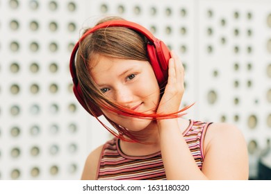 Outdoor Portrait Of Happy Young Teen Girl With Stylish Red Dyed Short Hair, Child Listening Music With Headphones