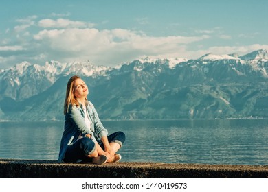 Outdoor Portrait Of Happy Young Woman Relaxing By The Lake On A Nice Sunny Day, Peacful And Harmonious Mood