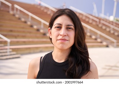 Outdoor portrait of a Latina woman looking at the camera with a serious face. Close up of a human face. Concept of people and emotions.