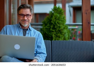 Outdoor Portrait Of Mid Adult Man In 50s, Happy Confident Smile. Working With Laptop Computer In Home Office. Mature Age, Middle Age, Bearded.