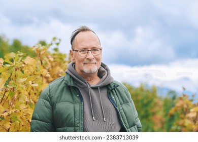 Outdoor portrait of middle age 55 - 60 year old man enjoing nice autumn day in vineyards, healthy and active lifestyle - Powered by Shutterstock