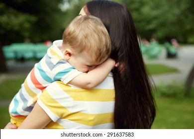 Outdoor Portrait Of Mother And Son. Child And Mom Walk In The Summer Park. Sad Crying Baby