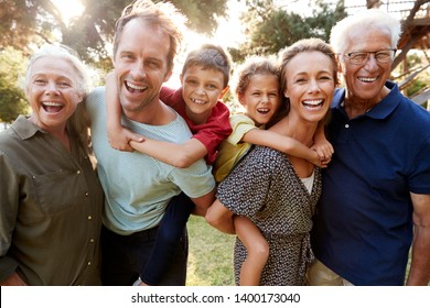Outdoor Portrait Of Multi-Generation Family Walking In Countryside Against Flaring Sun